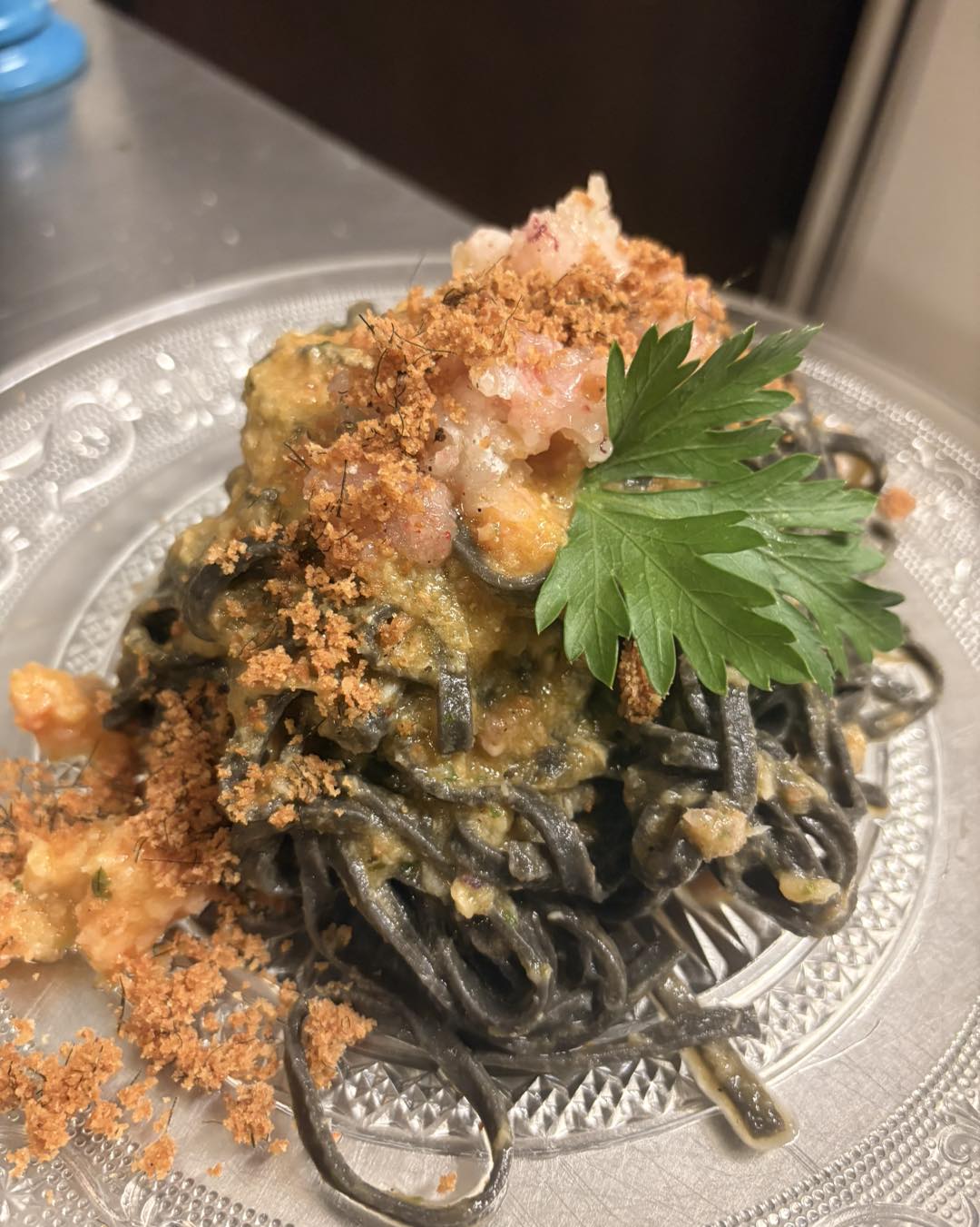 Spaghetti al nero di seppia con gamberi rossi e briciole croccanti