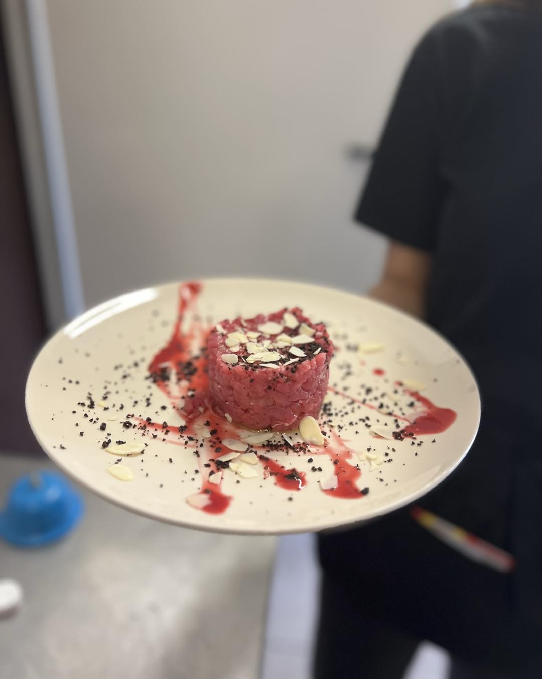 Tartare dello chef impiattata con salsa ai frutti rossi